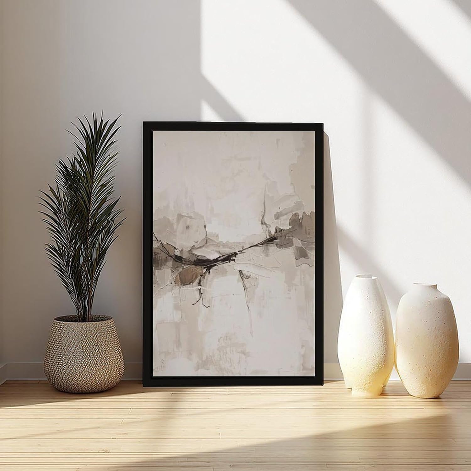Neutral abstract wall art in a black frame styled in an entryway vignette